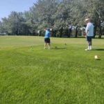 Judy teeing off with Coach watching